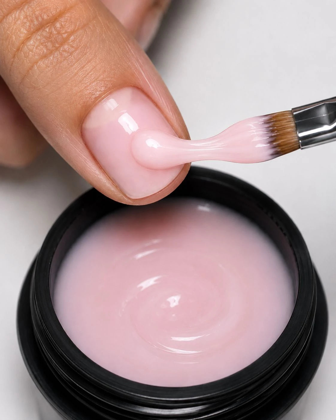 Texture du Builder Gel Milky Rose The French Touch appliquée au pinceau au-dessus du pot