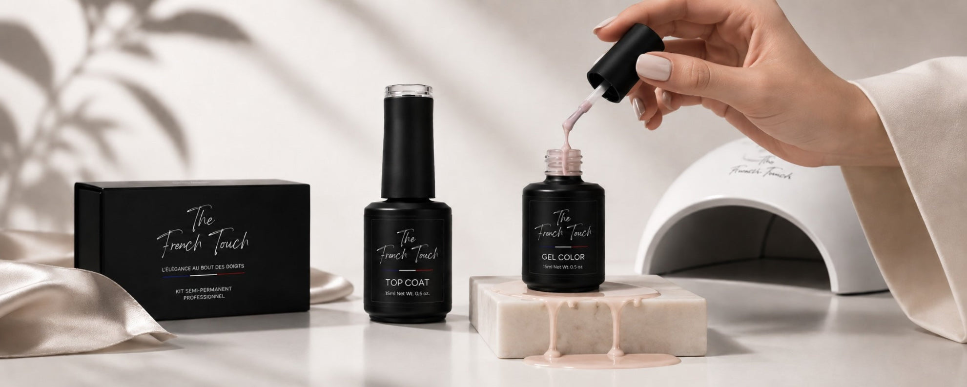 Kit semi-permanent professionnel The French Touch avec flacon top coat et gel color rose nude, application sur ongle sur fond marbre blanc et soie beige